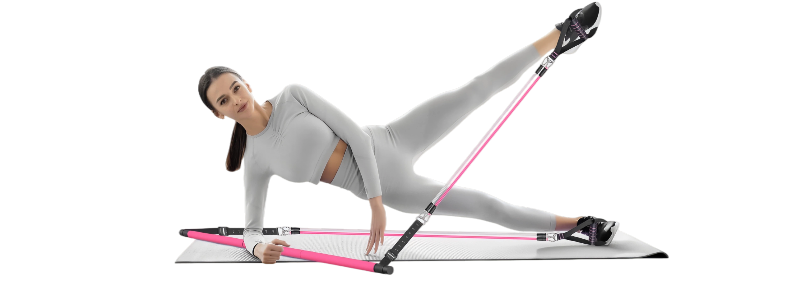 Woman performing a side leg lift exercise with a pink pilates bar kit on a yoga mat, demonstrating lower body and core training for home fitness.