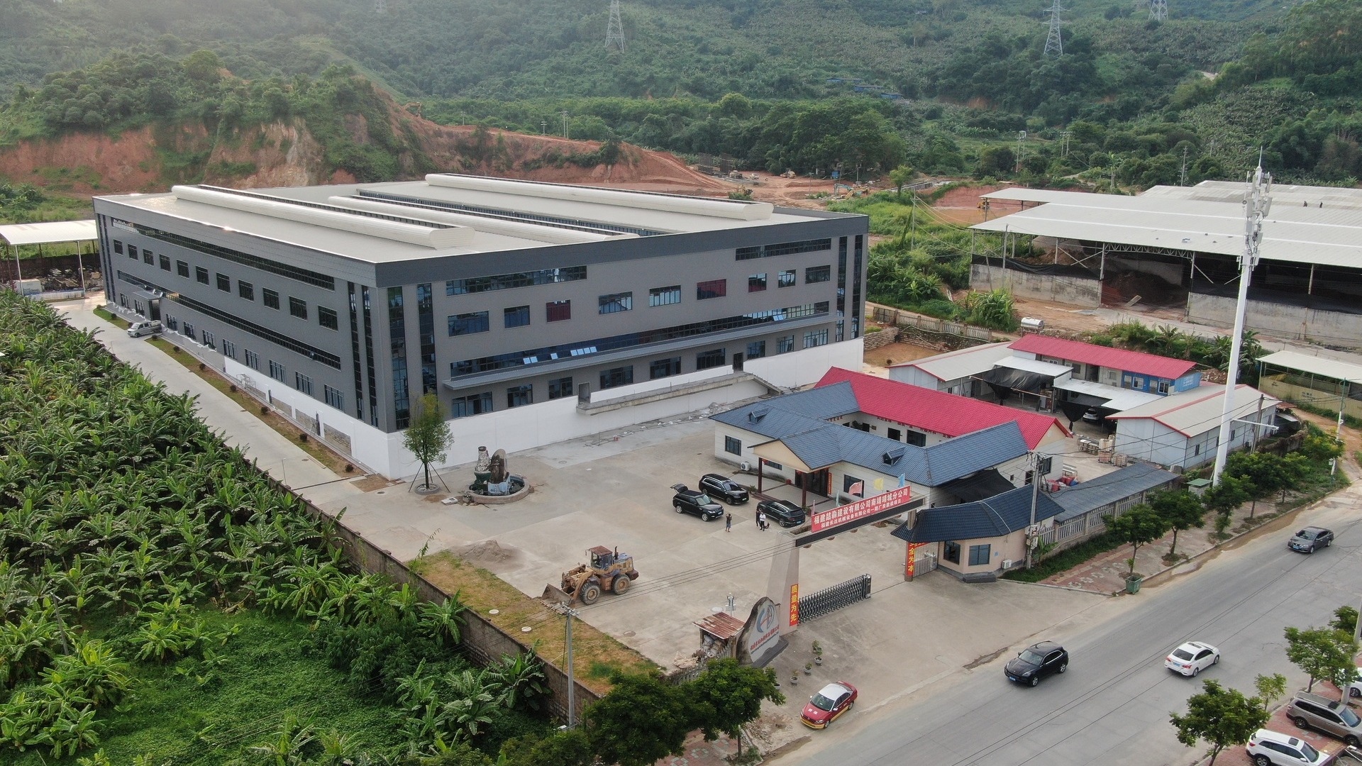 Aerial view of a modern factory campus surrounded by greenery, showcasing large-scale manufacturing capabilities and a professional production base for B2B clients.